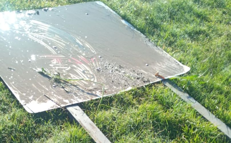 Cartel tumbado y vandalizado
