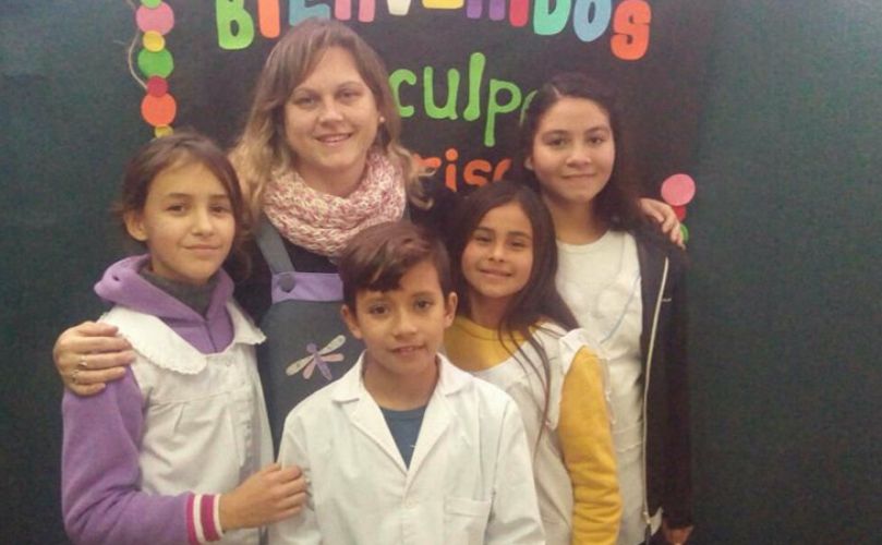 Daniella Zilli junto a algunos de los alumnos extienden la invitación 