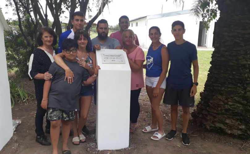 Su familia junto con la placa en el predio